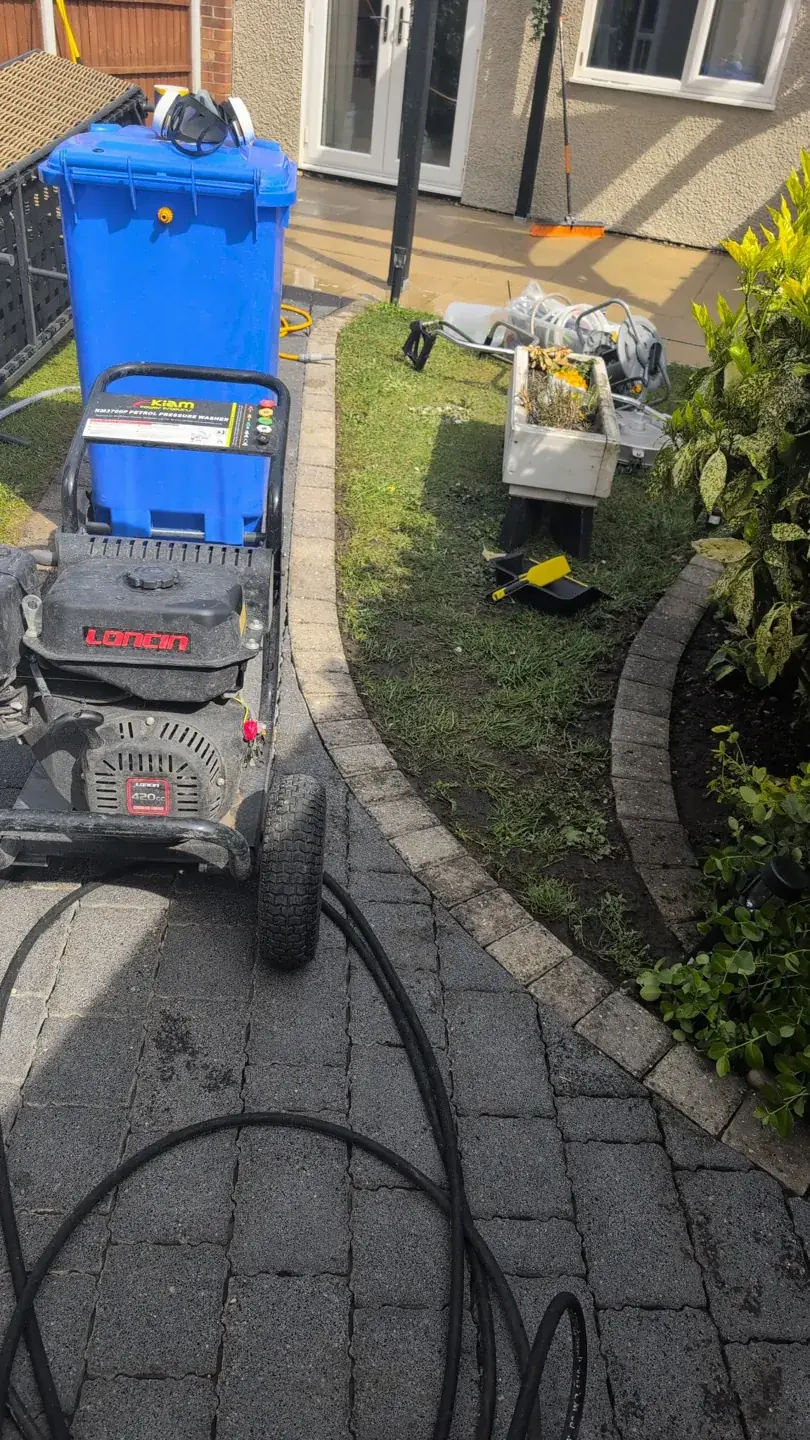 Professional exterior cleaning equipment prepared beside a garden path
